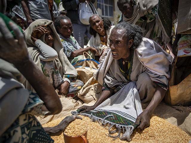 An Ethiopian woman argues with others over the allocation of yellow split peas distributed