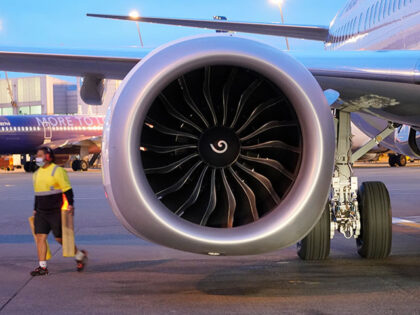 A ramp worker walks near one of two CFM International LEAP-1B engines on a Boeing 737-9 Ma