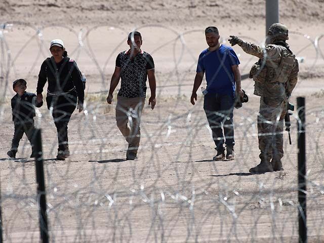 Migrants wait for U.S. authorities, between a barbed-wire barrier and the border fence at the US-Mexico border, as seen from Ciudad Juarez, Mexico, Wednesday, May 10, 2023. The U.S. on May 11 began to deny asylum to migrants who show up at the U.S.-Mexico border without first applying online or …