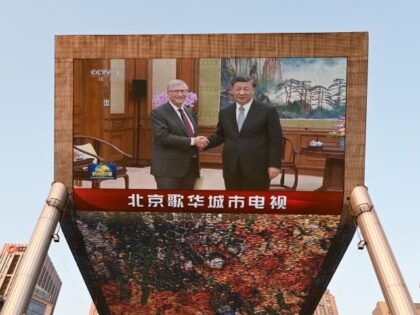 A China Central Television news broadcast shows footage of Microsoft co-founder Bill Gates (L) meeting with Chinese President Xi Jinping, on a giant screen outside a shopping mall in Beijing on June 16, 2023. President Xi Jinping told his "old friend" Bill Gates on June 16 that China had always …
