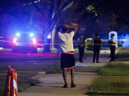 A person watches as officers work the scene where five people were shot during a Father&apos;s Day gathering at Wendell Smith Park in the 9900 block of South Princeton Avenue in the Roseland neighborhood Sunday, June 18, 2023. (Armando L. Sanchez/Chicago Tribune/Tribune News Service via Getty Images)