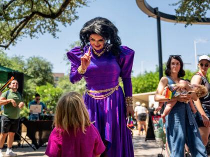 AUSTIN, TEXAS - JUNE 10: Austin, Tx drag queen Tequila Rose greets a child during a drag t