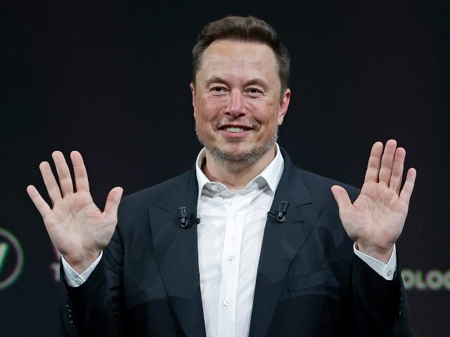Elon Musk puts his hands up