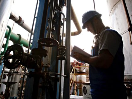 A Worker checks the quality of ethanol at the distillation plant at the Jalles Machado SA