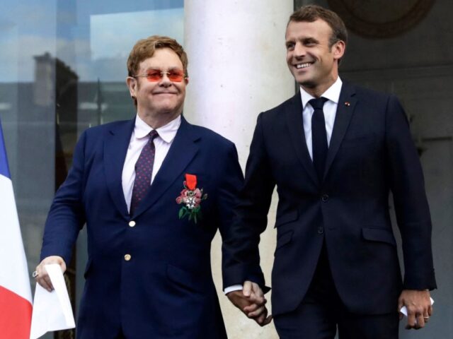 TOPSHOT - French President Emmanuel Macron (R) and British singer-songwriter Elton John ar