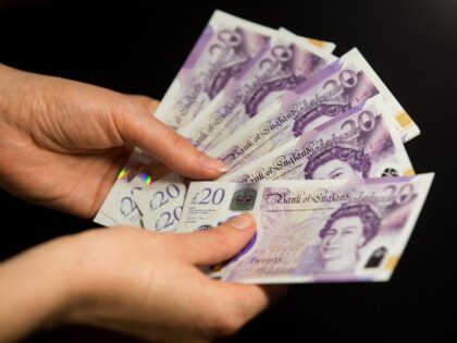 UNITED KINGDOM - 2020/06/06: In this photo illustration banknotes of the pound sterling, The Bank of England £20 notes with the image of Queen Elizabeth II are seen in a woman's hand. (Photo Illustration by Karol Serewis/SOPA Images/LightRocket via Getty Images)