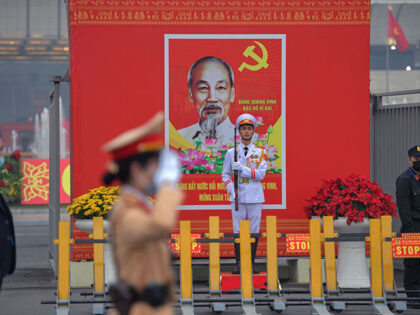 Police personnel stands guard in front of a billboard for the Communist Party of Vietnam's (CPV) 13th National Congress outside the National Convention Centre in Hanoi on January 26, 2021. (Photo by Nhac NGUYEN / AFP) (Photo by NHAC NGUYEN/AFP via Getty Images)