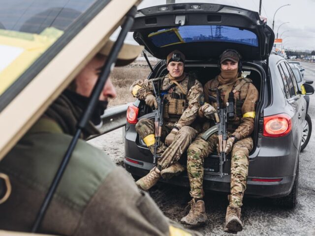 Ukrainian soldiers rest on a car in Irpin, Ukraine, on March 4, 2022. (Photo by Diego Herr
