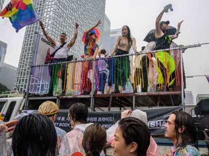 Participants take part in a parade as it rains heavily during a Pride event in support of LGBTQ rights as part of the Seoul Queer Culture Festival in Seoul on July 16, 2022. - Pride returned to the streets of Seoul on July 16 after a two-year, pandemic-related hiatus, with …