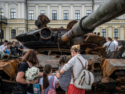 KYIV, UKRAINE - 2022/06/26: Mothers with their children observed a destroyed Russian T-72