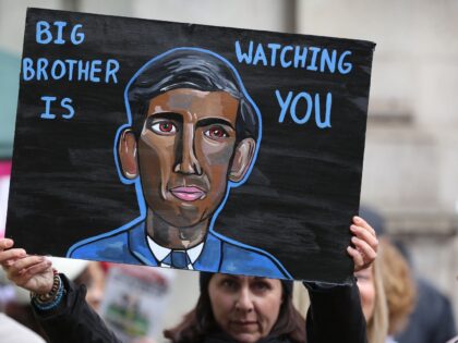 LONDON, ENGLAND - NOVEMBER 05: A protester holds up a sign saying 'Big Brother is WatchingYou' with a portrait of Prime Minister Rishi Sunak as protesters gather before their march across London on November 5, 2022 in London, England. Many different groups came together to criticise the Conservative government and …