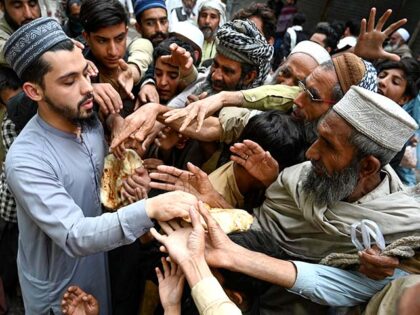 Men collect free bread from a distribution point in Peshawar on April 3, 2023. - Poor Paki