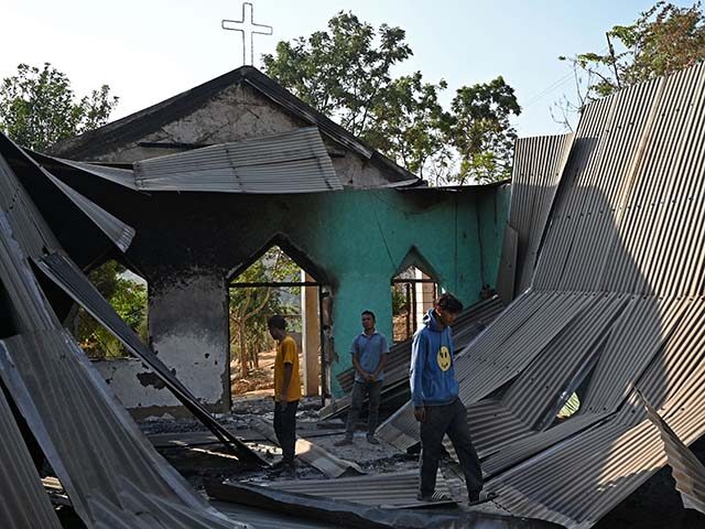Villagers inspect the debris of a ransacked church that was set on fire by a mob in the et