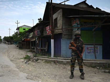 A Indian serviceman stands guard during a curfew at Oinam bazaar of Bishnupur as violence