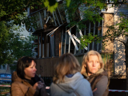 KYIV, UKRAINE - JUNE 1: A damaged building is seen behind women after a Russian aerial attack on a children's hospital and a residential building in Kyiv, Ukraine, on June 1, 2023. At least three people, including one child, were killed and 10 others wounded as Russian forces launched a …