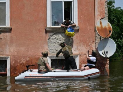TOPSHOT - Servicemen of the National Guard of Ukraine deliver food to the residents of a flooded area in Kherson on June 8, 2023, following damages sustained at Kakhovka hydroelectric power plant dam. Ukraine and Russia accused each other of shelling in the flood-hit Kherson region on June 8, 2023 …