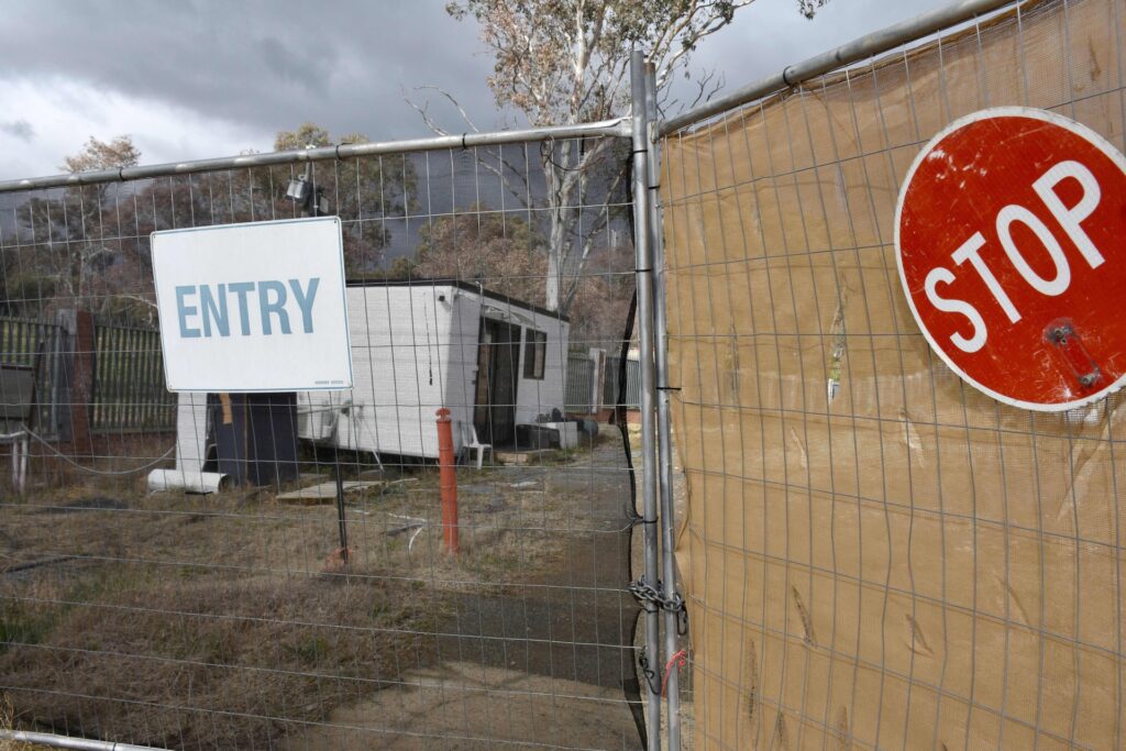 TOPSHOT - A portable security shed surrounded by weeds and discarded building materials is seen on a vacant land, which is a proposed new Russian embassy site, in Canberra on June 23, 2023. A mystery Russian diplomat with a penchant for cigarettes on June 23, sparked a national security standoff between Canberra and the Kremlin, which is defying Australia's efforts to kick him off a messy building site near parliament. (Photo by Yoann CAMBEFORT / AFP) (Photo by YOANN CAMBEFORT/AFP via Getty Images)