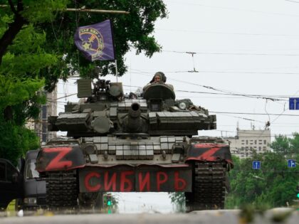TOPSHOT - Members of Wagner group sit atop of a tank in a street in the city of Rostov-on-