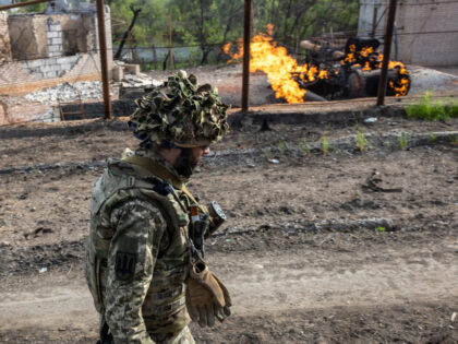 KHARKIV, UKRAINE - MAY 13: A Ukrainian Army soldier walks past a burning natural gas terminal on May 13, 2022 on the northern outskirts of Kharkiv, Ukraine. Ukrainian and Western officials say Russia is withdrawing forces around Kharkiv, Ukraine's second-largest city, suggesting it may redirect troops to Ukraine's southeast. (Photo …