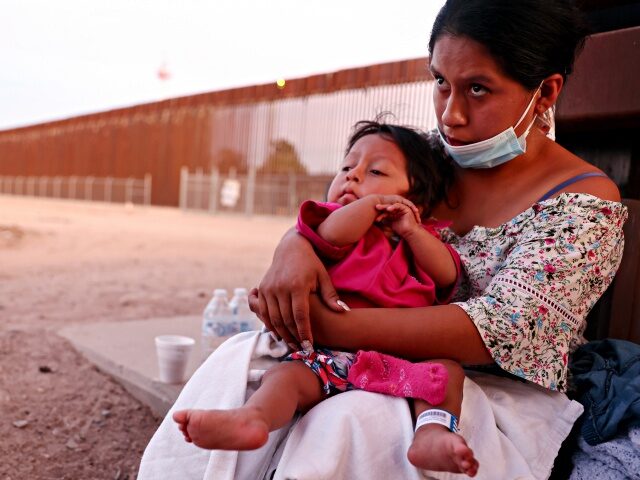 SAN LUIS, ARIZONA - MAY 23: An immigrant mother holds her one-year-old son, after they were released from a local hospital where her son was treated for dehydration after crossing the border from Mexico, as they wait to be processed by U.S. Border Patrol, on May 23, 2022 in San …
