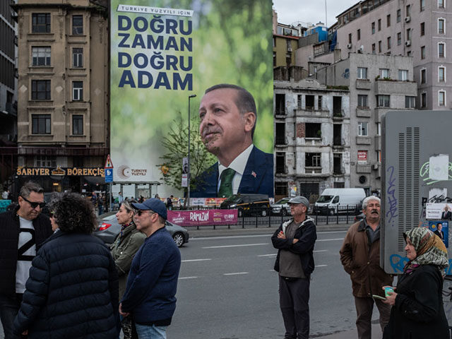 ISTANBUL, TURKEY - MAY 10: People wait bus in front of a poster showing the portrait of Turkey's President Recep Tayyip Erdogan on May 10, 2023 in Istanbul, Turkey. On May 14th, Turkey’s President Erdogan will face his biggest electoral test as the country goes to the polls in the …