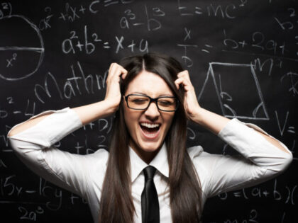 Female economist screaming in front of a blackboard