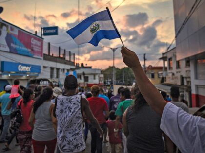 TOPSHOT - A migrant -alongside other Central Americans taking part in a caravan called "Migrant Viacrucis" towards the United States- flutters a Guatemalan national flag during a march to protest against US President Donald Trump's policies in Matias Romero, Oaxaca State, Mexico, on April 3, 2018. - The hundreds of …