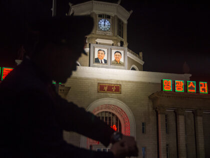 A photo taken on May 5, 2018 shows a traffic policeman checking his watch before the central railway station in Pyongyang. - North Korea went forward in time by 30 minutes, state media said late on May 4, to match its clocks with those of the South following the inter-Korean …