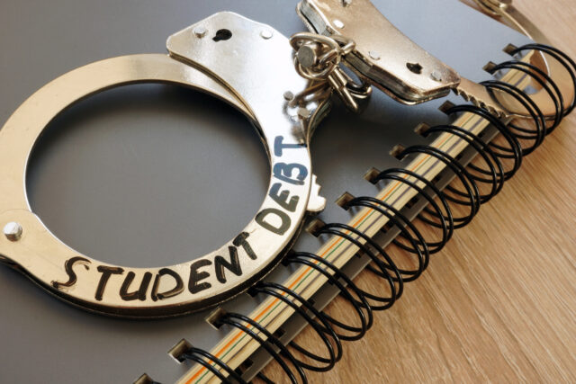 Handcuffs with sign student debt and notebook.