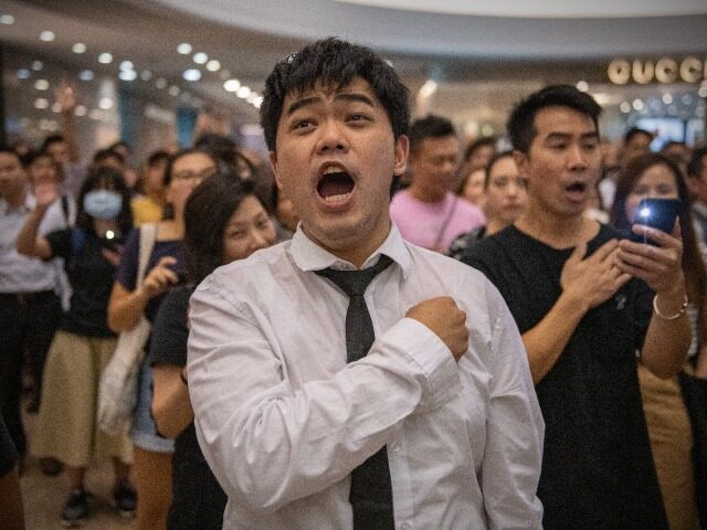HONG KONG, CHINA - SEPTEMBER 12: A protester holds his hand against his chest as he sings the Glory to Hong Kong protest "anthem" during a demonstration in Times Square shopping mall on September 12, 2019 in Hong Kong, China. Pro-democracy protesters have continued demonstrations across Hong Kong despite the …