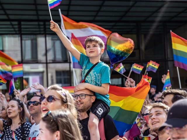 WROCLAW, POLAND - 2022/06/11: A young boy carried on his father shoulders waves a pride flag during the Pride rally. The 14th pride procession was held Wroclaw. It was focused not only on equality, but also on current events on Ukraine and abortion law restrictions. During the march a group …