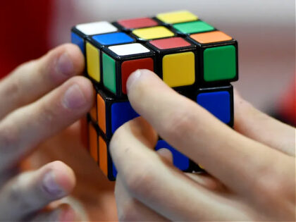 FILE - A gamer plays with Rubik's Magic Cube at the international game fair 'SPIEL' in Ess