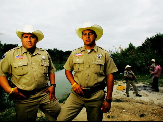 Sheriff's deputies Abel Hinojosa (l) and Morcos Pampa, by the Rio Grande which marks the b