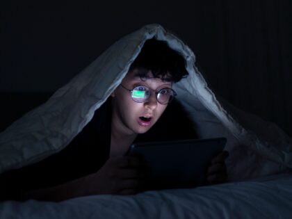 Teen surprised by tablet in bed