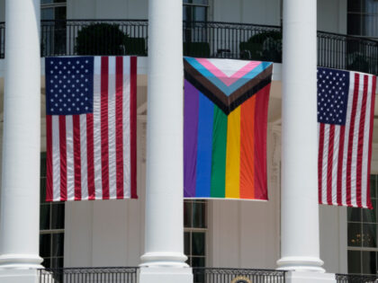 American flags and a pride flag hang from the White House before a Pride Month celebration