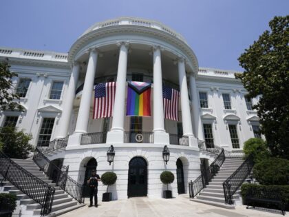 American flags and a pride flag hang from the White House during a Pride Month celebration