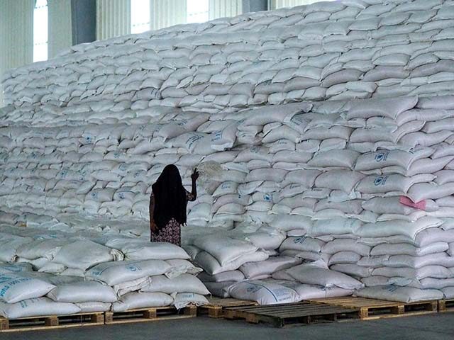 A worker walks next to a pile of sacks of food earmarked for the Tigray and Afar regions i