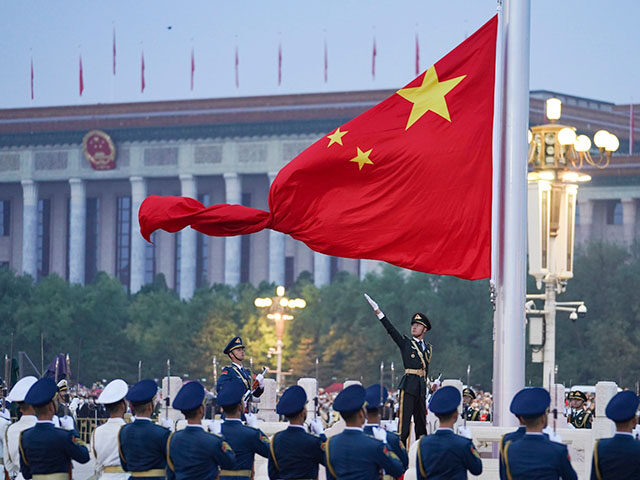 In this photo released by Xinhua News Agency, a member of the Chinese honor guard unfurls the Chinese national flag during a flag raising ceremony to mark the 73rd anniversary of the founding of the People's Republic of China held at the Tiananmen Square in Beijing on Oct. 1, 2022. …