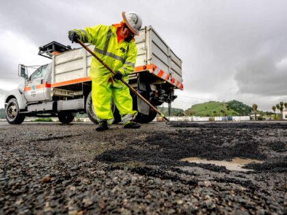 Pomona, CA - March 22: Pomona, CA - March 22: A CalTrans worker repairs potholes that caus