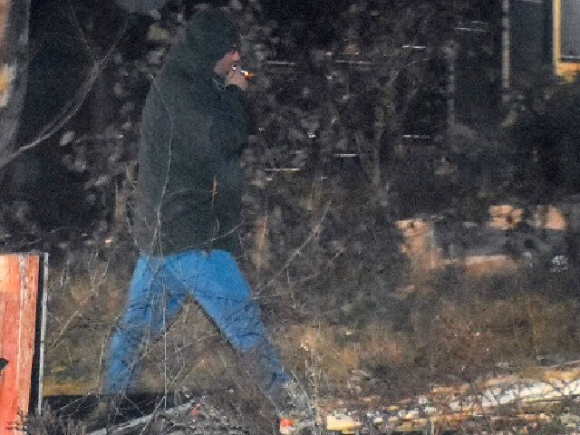 A Russian diplomat smokes a cigarette on a parcel of land where Australia blocked Russia f