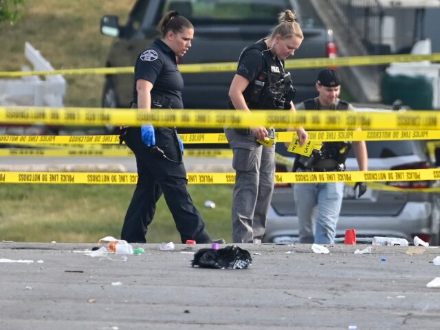 Investigators look over the scene of an overnight mass shooting at a strip mall in Willowbrook, Ill., Sunday, June 18, 2023. (AP Photo/Matt Marton)