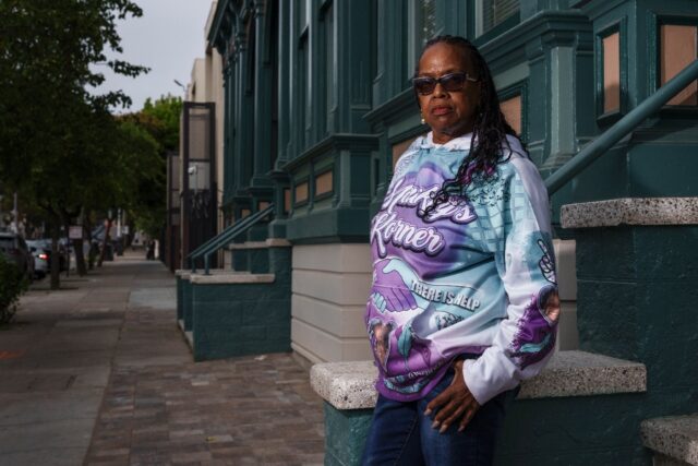 Lynette Mackey, whose family once resided in the Fillmore district, stands outside their f