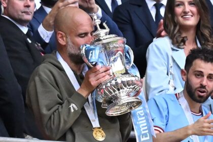 Manchester City boss Pep Guardiola holding the FA Cup after his team beat Manchester Unite
