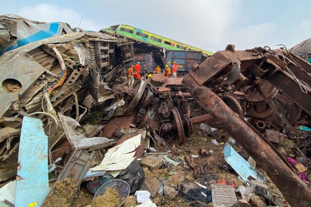 Rescue workers search for survivors at the accident site of a three-train collision near Balasore, India