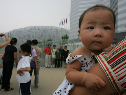 Visitors gather to look at the National Stadium, known as the Bird's Nest, a month be