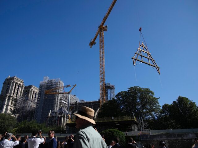 A crane lifts a huge oak frame at Notre Dame de Paris cathedral, Tuesday, July 11, 2023 in