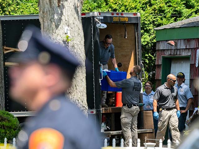New York State police officers place items into the back of a box truck as law enforcement