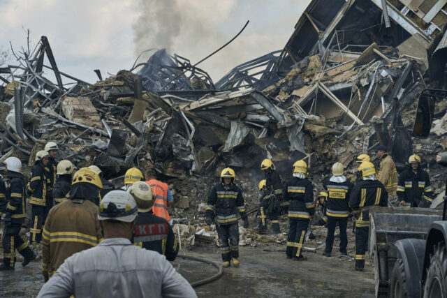 Emergency service personnel work at the site of a destroyed building after a Russian attac