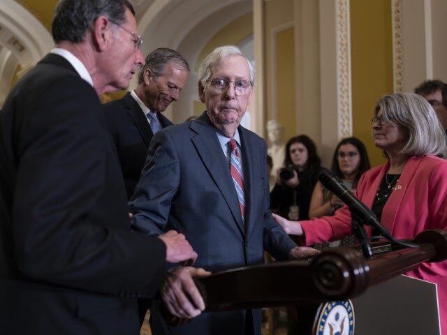Senate Minority Leader Mitch McConnell, R-Ky., center, is helped by, from left, Sen. John