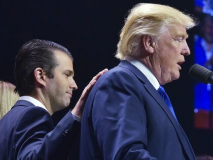Donald Trump, Jr., (L) places a hand on the shoulder of his father, Republican presidentia